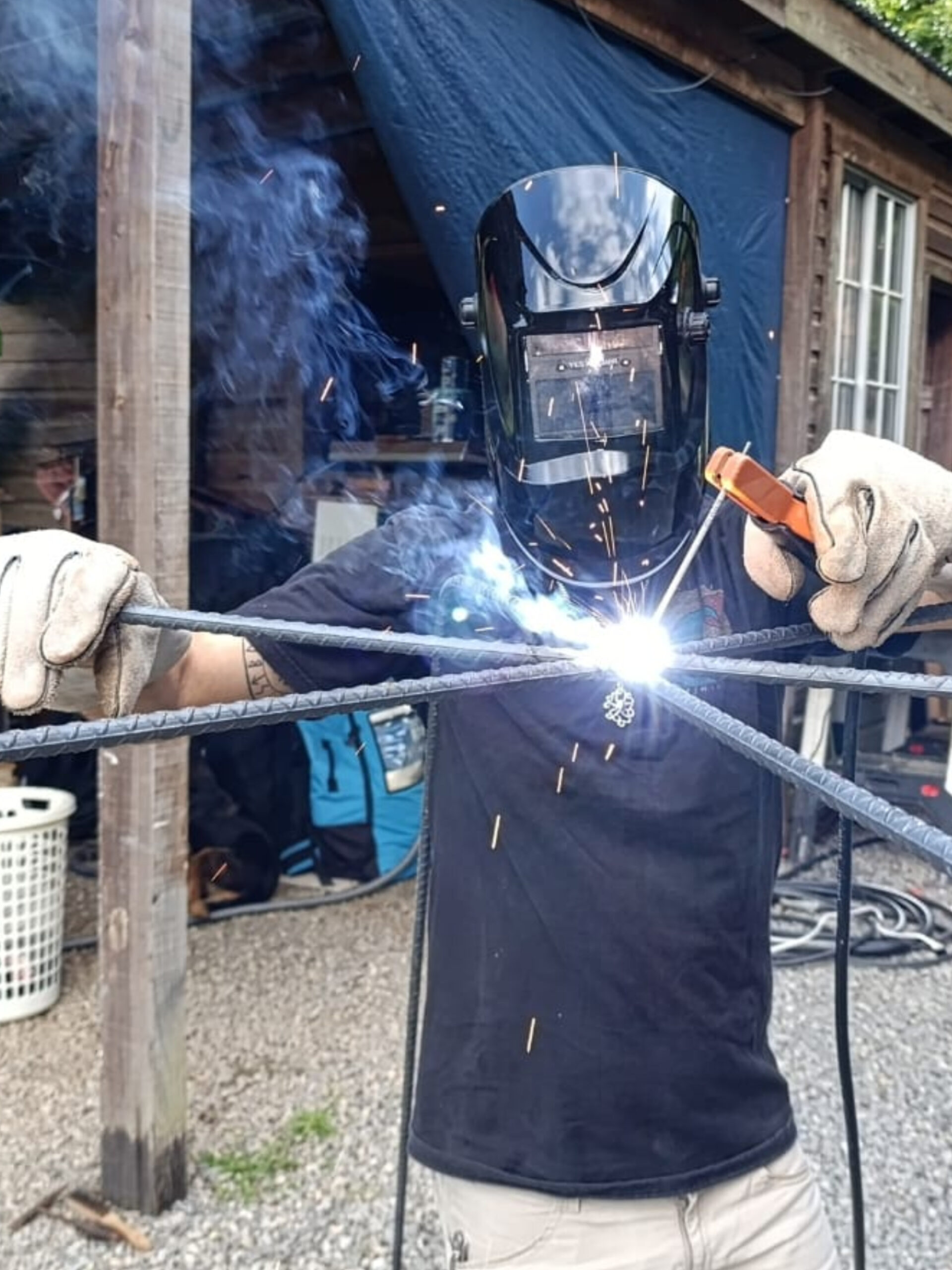 Team member welding a metal structure for a coral restoration nursery in Roatan.