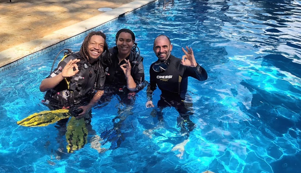 First-time divers practicing scuba skills in the swimming pool with an instructor